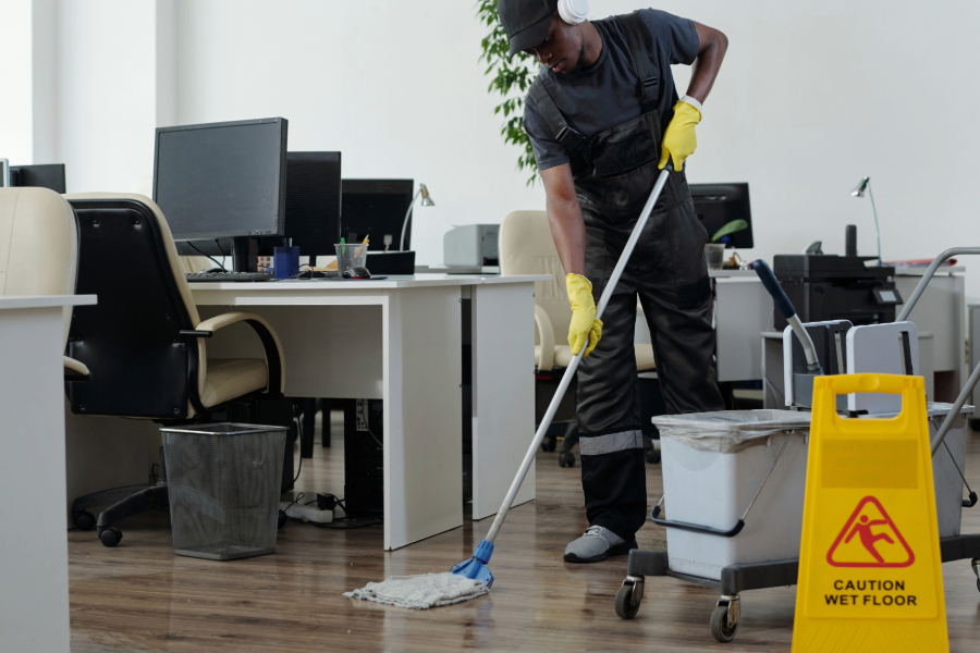 A commercial cleaning worker mopping an office floor—an example of a economical cleaning service for small businesses