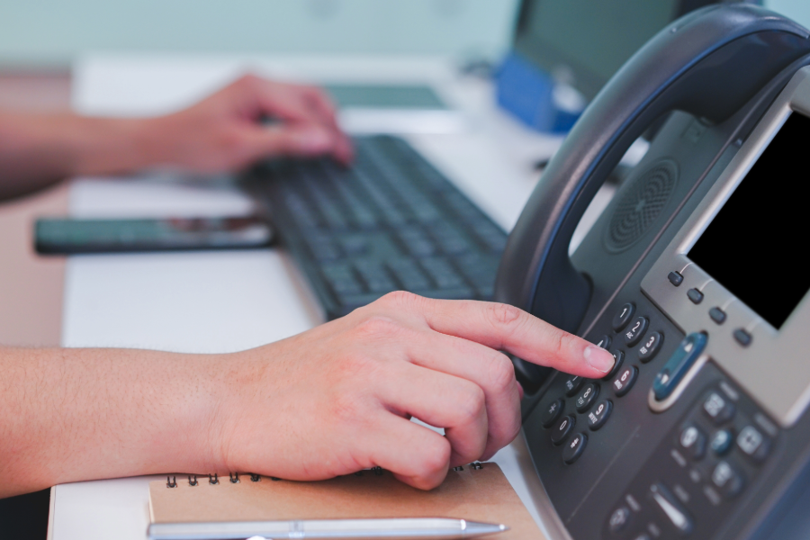 A close-up shot of a common germ hotspot (an office phone) which is a part of cleaning strategies for reducing germs in commercial spaces