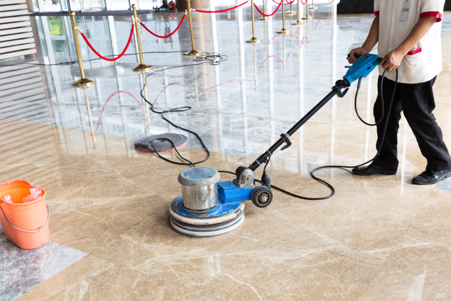 A professional cleaning team performing a deep clean in a commercial space; buffing marble flooring, keeping commercial space germ-free